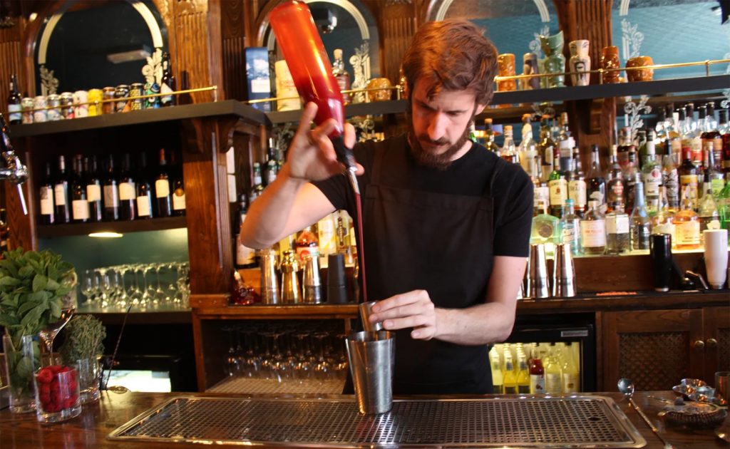 Bartender pouring a drink in Chambers Cocktail Company 